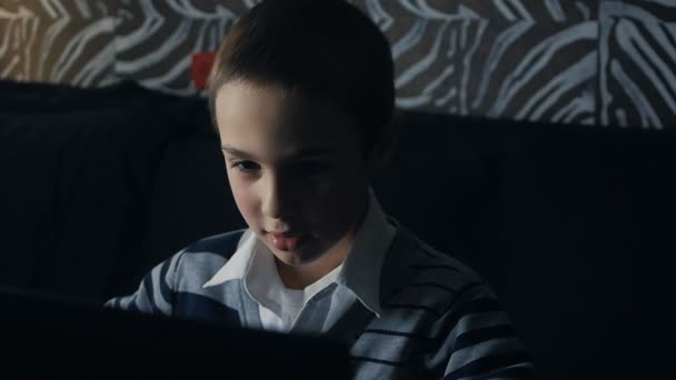 petit garçon jouant sur un ordinateur portable à la maison 