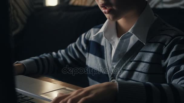 Jongetje computerspelletjes spelen op een laptop thuis — Stockvideo