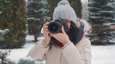 kadın fotoğrafçı çekim kış karla kaplı parkta alır.