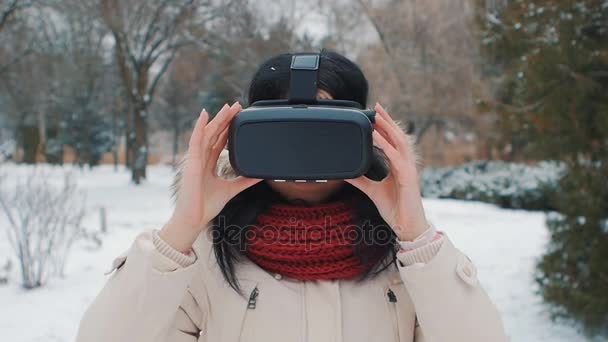 Joven mujer obtener experiencia en el uso de VR-auriculares al aire libre en el parque de invierno — Vídeos de Stock