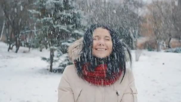 De la poudrerie. Beauté Joyeux adolescent modèle fille s'amuser dans le parc d'hiver. Belle fille soufflant de la neige et tournant à l'extérieur. Profiter de la nature . — Video