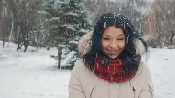 雪を吹きます。うれしそうな 10 代モデル美少女冬の公園で楽しんでいます。雪を吹くと回転して屋外の美しい少女。自然を楽しむ. — ストック動画