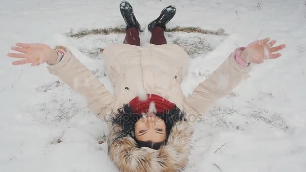 Belleza alegre adolescente modelo chica divertirse en el parque de invierno. Hermosa chica soplando nieve y girando al aire libre. Disfrutando de la naturaleza . — Vídeos de Stock