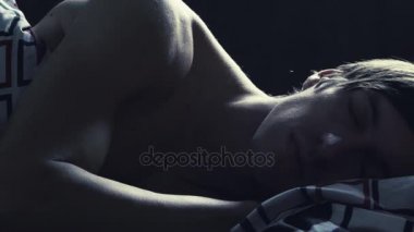 Genç adam evde yatağında geceleri uyuyor