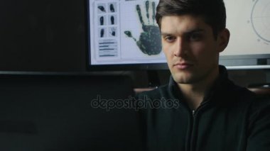 Genç mühendis hacker adam karanlık odada, bir dizüstü bilgisayar üzerinde çalışıyor