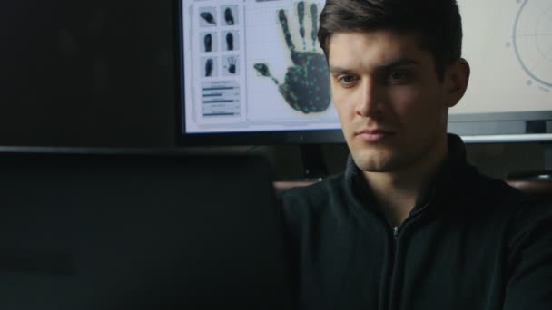 Νέος μηχανικός χάκερ άνδρας εργάζεται πάνω σε ένα φορητό υπολογιστή στο σκοτεινό δωμάτιο — Αρχείο Βίντεο