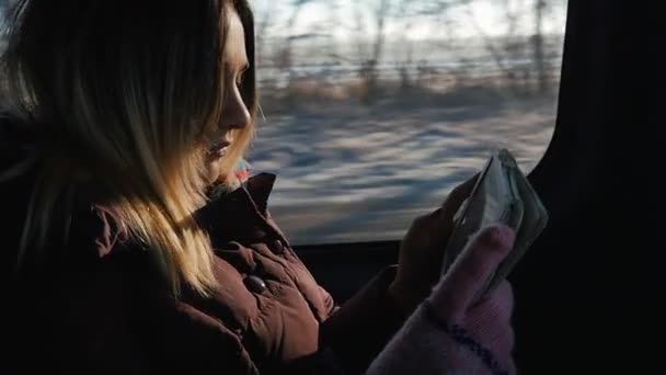 Mujer joven viajando en coche en un día soleado. Ella usando tableta pc — Vídeos de Stock
