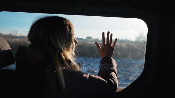 車の窓から外を見て女の子。日当たりの良い天気 — ストック動画