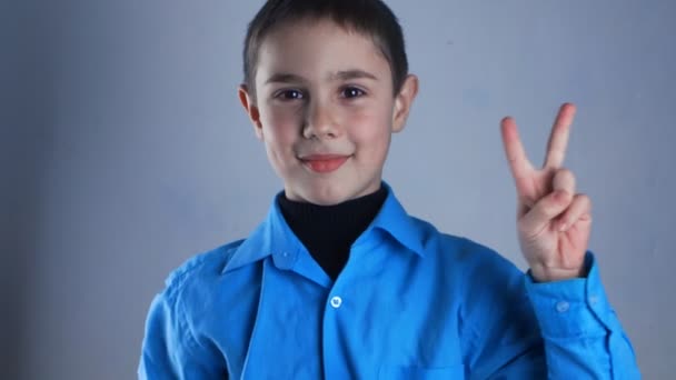ハンサムな男の子は、平和の兆候を示しています。 — ストック動画