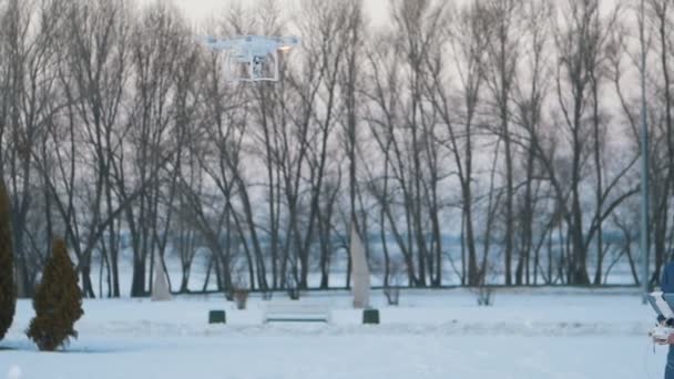 Um homem controla um drone no jardim de inverno — Vídeo de Stock