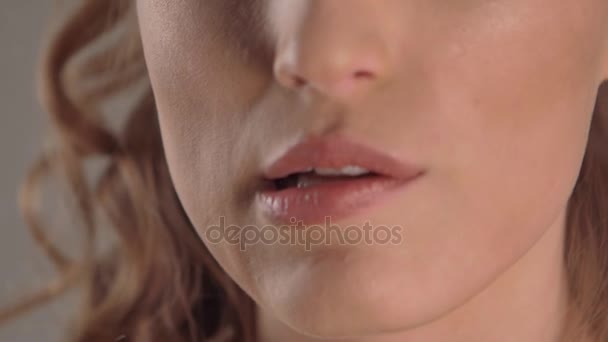 Primeros labios de mujer joven. Se muerde los labios en cámara lenta. — Vídeo de stock