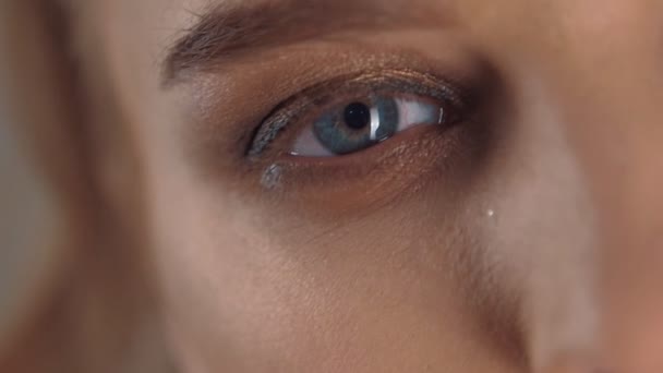 Primer plano de hermoso ojo azul de una joven en cámara lenta — Vídeo de stock