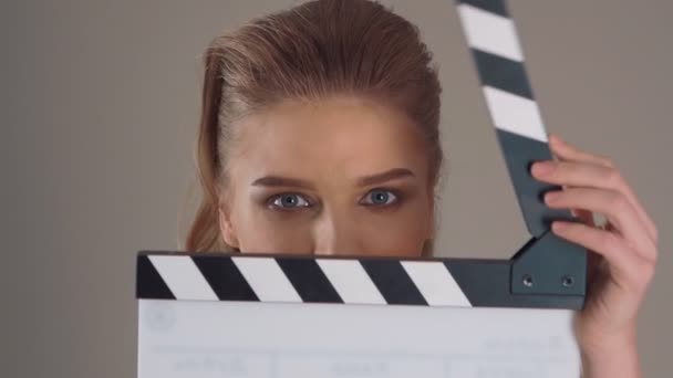 Syuting. Close up of Beautiful young woman with clapperboard in hands — Stok Video