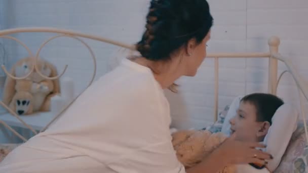 Bella mamma dare un bacio davanti al suo bambino prima di dormire e coprirla molto dolcemente con una coperta — Video Stock