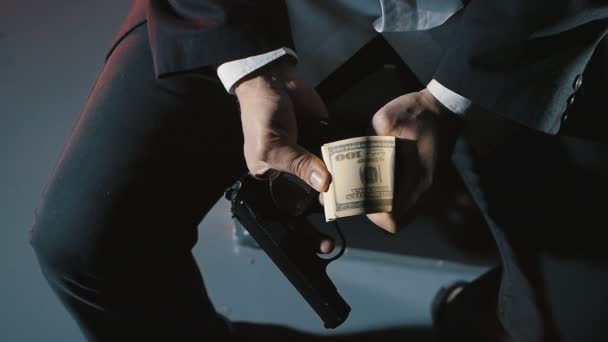 Крупным планом руки опасного человека с пистолетом считают деньги. Грязная мафия . — стоковое видео