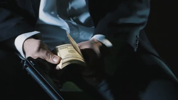 Närbild händerna på en farlig man med en pistol räknar pengar. Smutsiga pengar Mafia. — Stockvideo