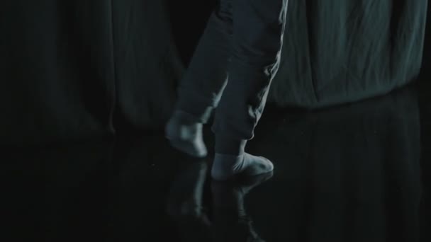 Босоногий мальчик ходит в темноте — стоковое видео