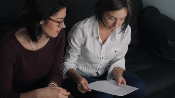 Деловая команда из двух женщин, работающих с документами, обсуждающих финансовые результаты и анализирующих статистику — стоковое видео