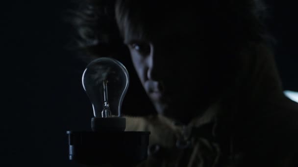 Man lights a lamp in a dark room — Stock Video