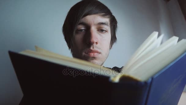 Hombre leyendo libro en casa — Vídeo de stock