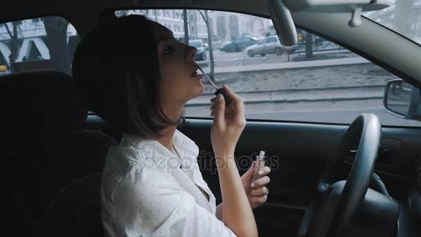 Mujer joven haciendo maquillaje en el coche — Vídeo de stock