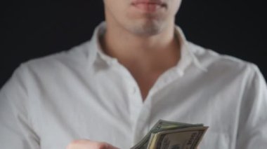 Beyaz gömlekli bir adam a bohça-in dolar alır ve faturaları inceliyor