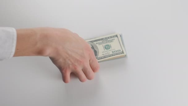 Close-up, een man krijgt een bundel van geld. Hij beschouwt dollarbiljetten — Stockvideo