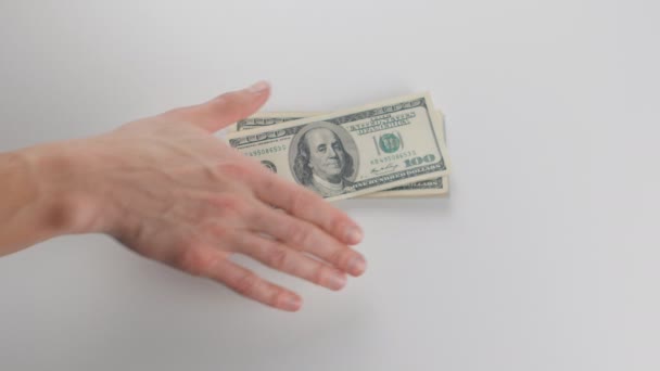 Close-up, een man krijgt geld. Hij beschouwt dollarbiljetten — Stockvideo