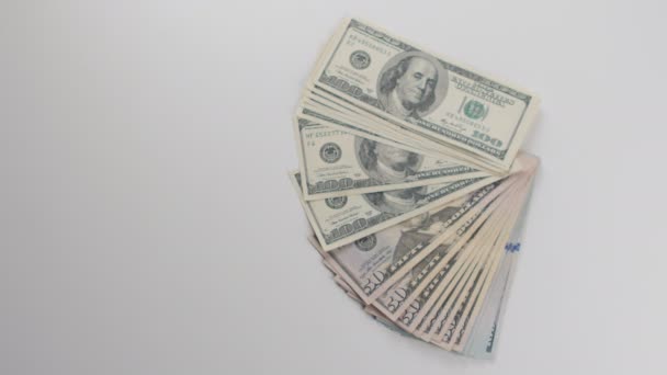 Close-up, een man krijgt geld. Hij beschouwt dollarbiljetten — Stockvideo
