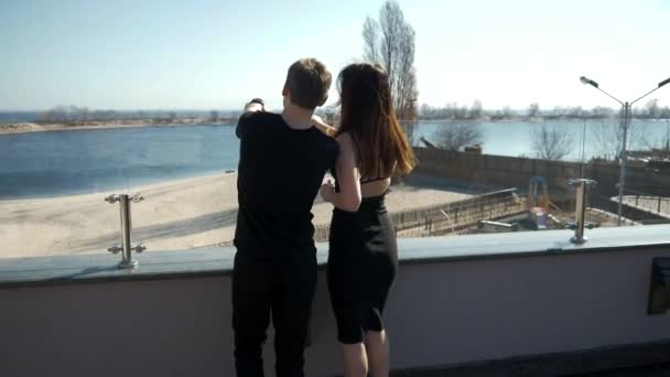 Jeune couple amoureux est debout sur la loggia et regarder la mer et rêver — Video