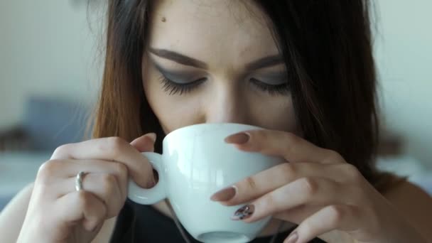 Close up Joven hermosa mujer bebe café en un café — Vídeo de stock