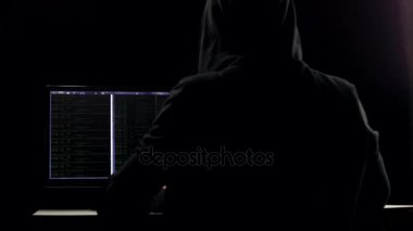 Hacker karanlık hacker odasından dizüstü bilgisayar ve bilgisayar kullanarak kod çatlama Hood