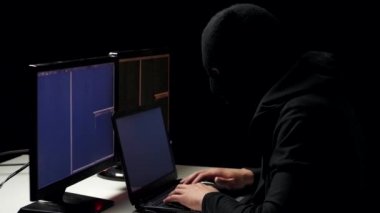 Hacker'karanlık hacker odasından dizüstü bilgisayar ve bilgisayar kullanarak kod çatlama yün