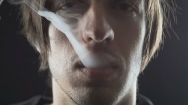 Adam vaper yavaş çekimde elektronik sigara ile duman yapar kapatın