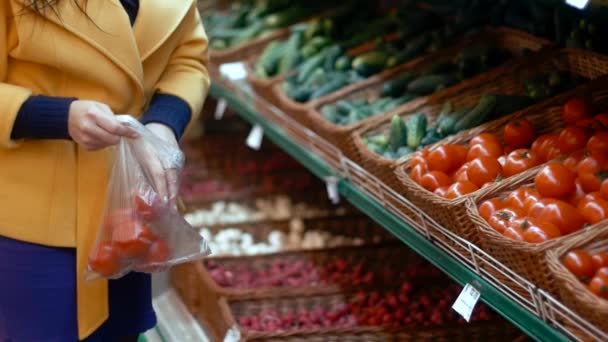 Mujer en un supermercado selecciona los tomates — Vídeo de stock