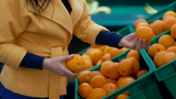 Mujer elige naranjas en un supermercado . — Vídeos de Stock