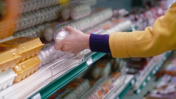 Mujer elige huevos en el supermercado — Vídeo de stock