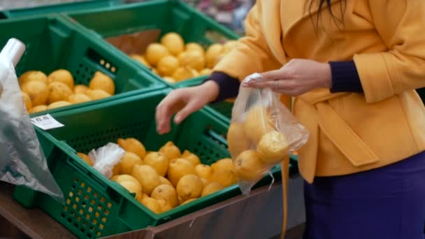 Жінка вибирає свіжий лимон у відділі виробництва продуктових магазинів . — стокове відео