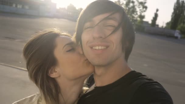 Селфі красива пара хлопець і дівчина цілуються один з одним під час заходу сонця. Вони щасливі — стокове відео
