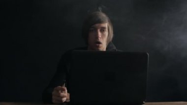 Dizüstü bilgisayar ve ağır çekimde atış bir Buharlaştırıcı duman Exhaling çalışan adam