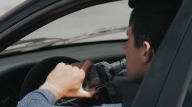 Sarhoş sürücü. Adam arabada votka içer