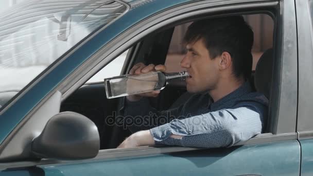 Пьяный водитель. Мужчина пьет водку в машине — стоковое видео