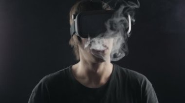 adam elektronik sigara içiyor ve bir sanal gerçeklik kask kullanır. Fütüristik vaper