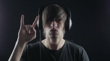 Kaya fan hard rock yapmak başını sallar. Adam Rock and Roll işareti veya şeytan boynuzu gösterir