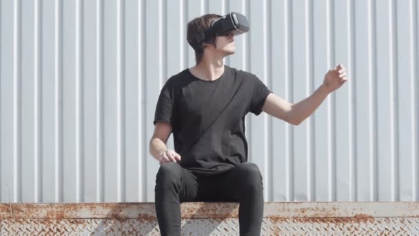 Joven hombre utiliza un virtual realidad gafas al aire libre — Vídeos de Stock