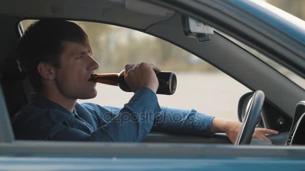 Un hombre bebiendo cerveza en el coche. Conductor borracho — Vídeo de stock