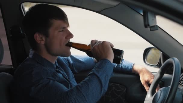 Un uomo che beve birra in macchina. Guidatore ubriaco — Video Stock