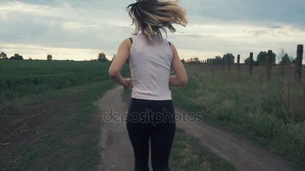 Жінка біжить в парку, займаючись на відкритому повітрі — стокове відео