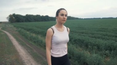 Atletik kız Road alanı yürüyüş. açık havada fitness. Steadicam ile vurdu