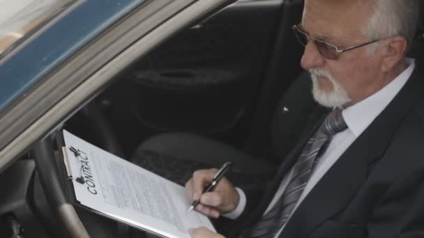 Geschäftsmann bei der Vertragsunterzeichnung im Auto sitzend. Chef macht einen Deal. — Stockvideo